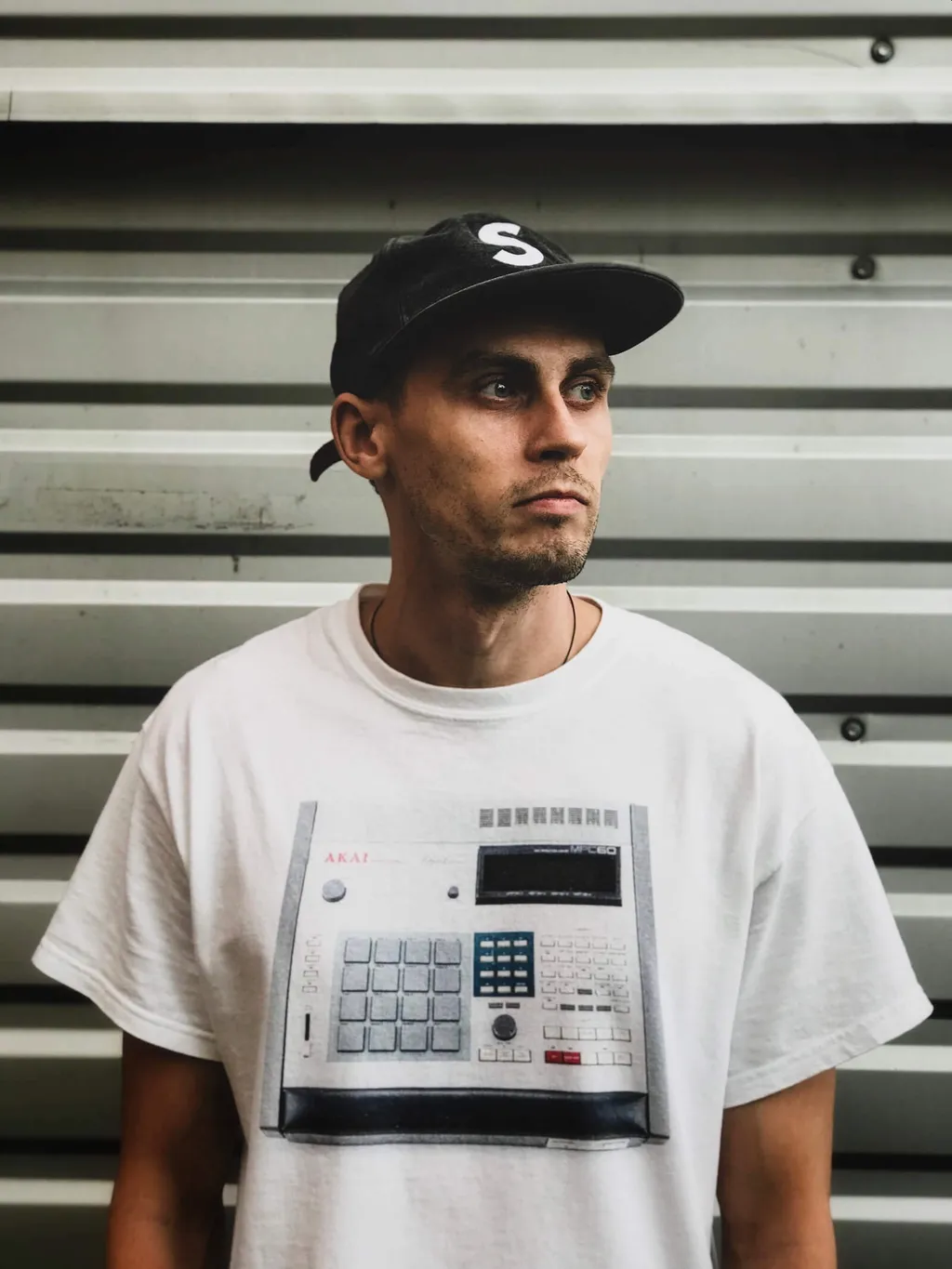 producer KLIM wearing shirt with AKAI DAW controller