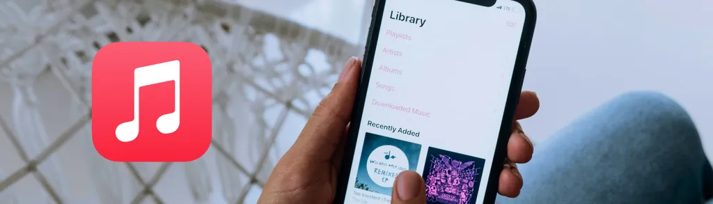 Hand holding smartphone displaying music library interface with album artwork, red music note app icon visible in corner.