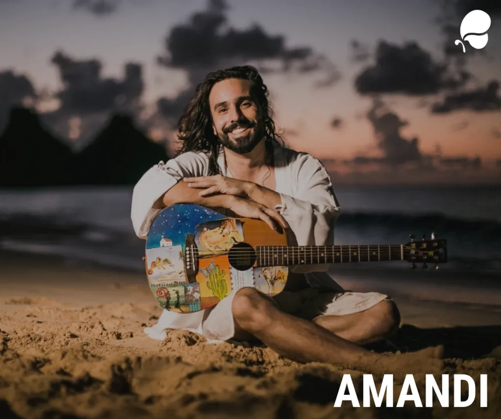 foto de homem sentado na praia segurando violão
