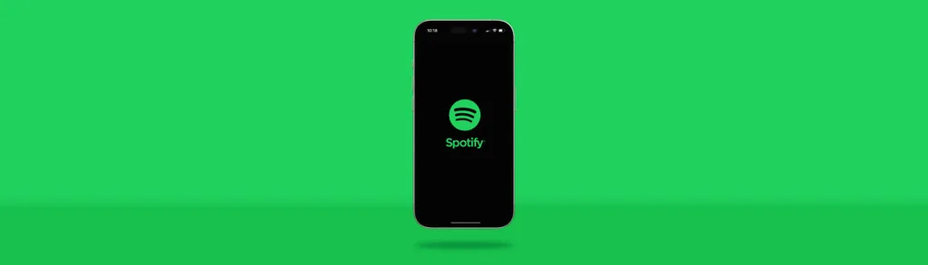 Black smartphone displaying Spotify logo on screen against bright green background.