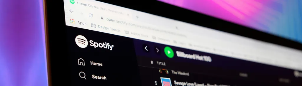 Computer screen displaying Spotify interface with dark sidebar showing Home and Search options against purple-pink gradient background.