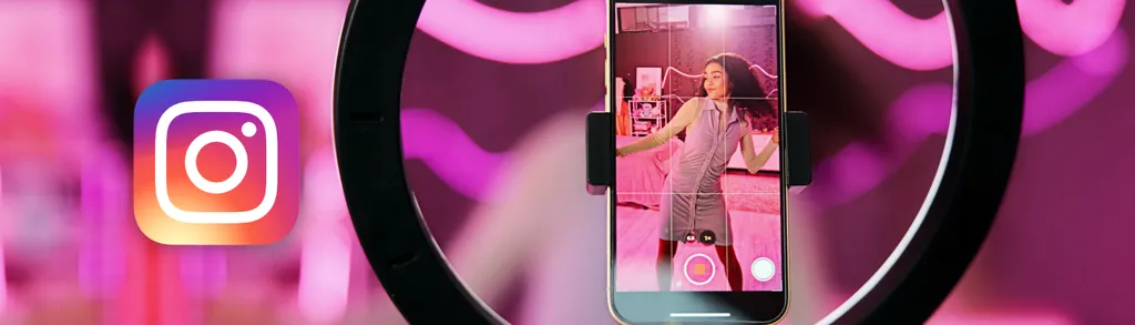 Black ring light with smartphone mounted in center showing woman on screen, Instagram logo on left, pink blurred background.