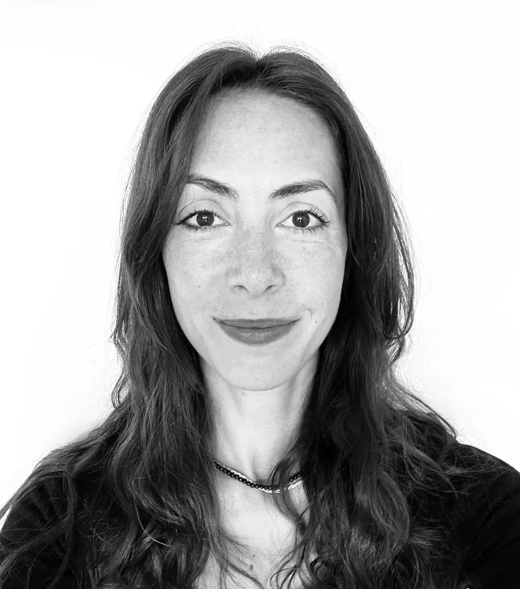 Headshot of a smiling woman with long, dark hair.