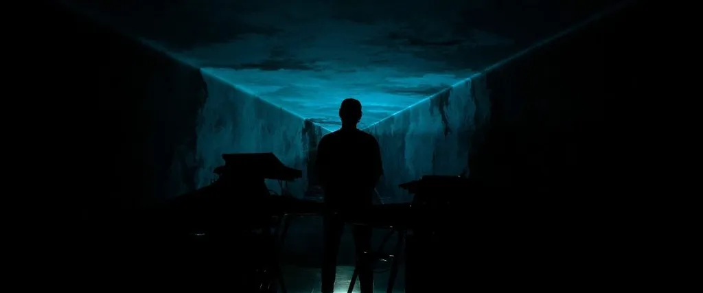 Photo de l'artiste Lydsten dans un espace sombre aux lumières bleues