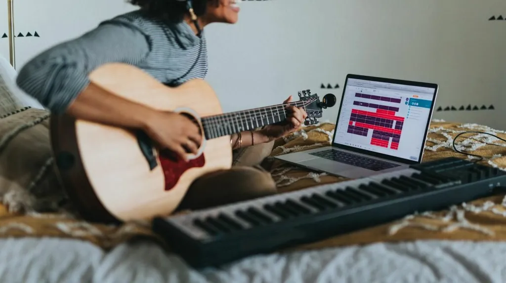 woman playing the guitar and keyboard sitting on bed