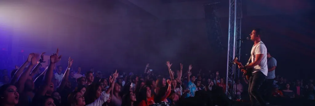 musician singing and playing guitar on stage