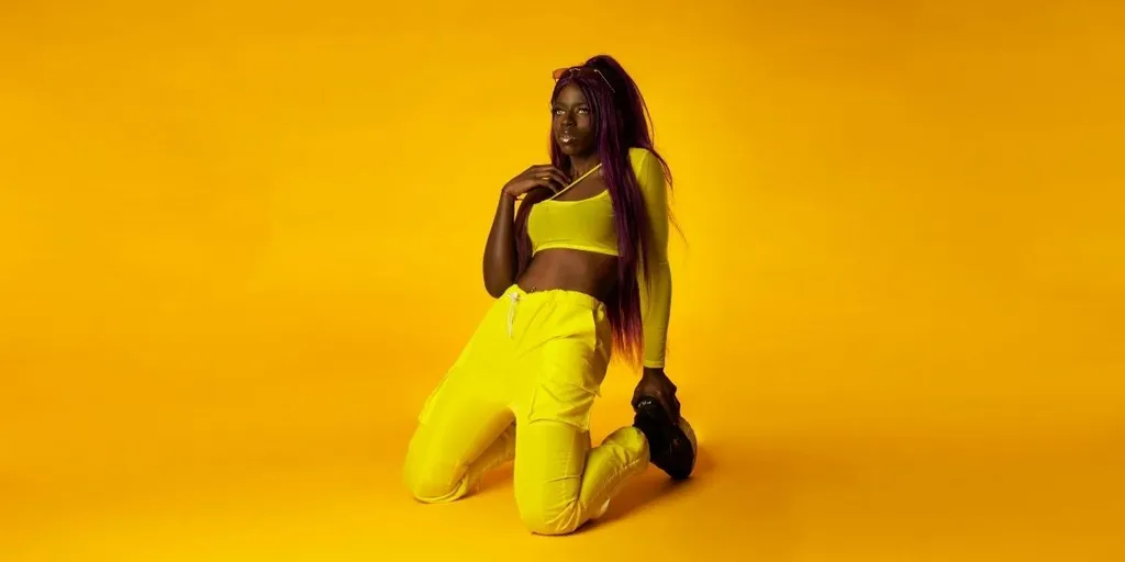 Foto promocional de Kiara Jones sobre fondo amarillo
