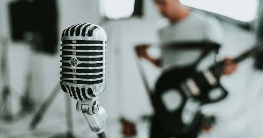 Microphone with guitarist in the background