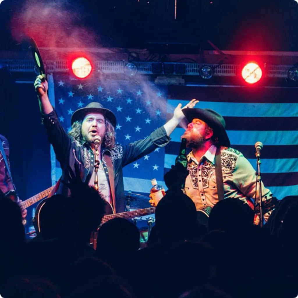 country singers on stage with American flag